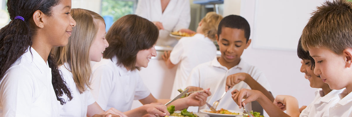Mixed primary pupils eating school meal